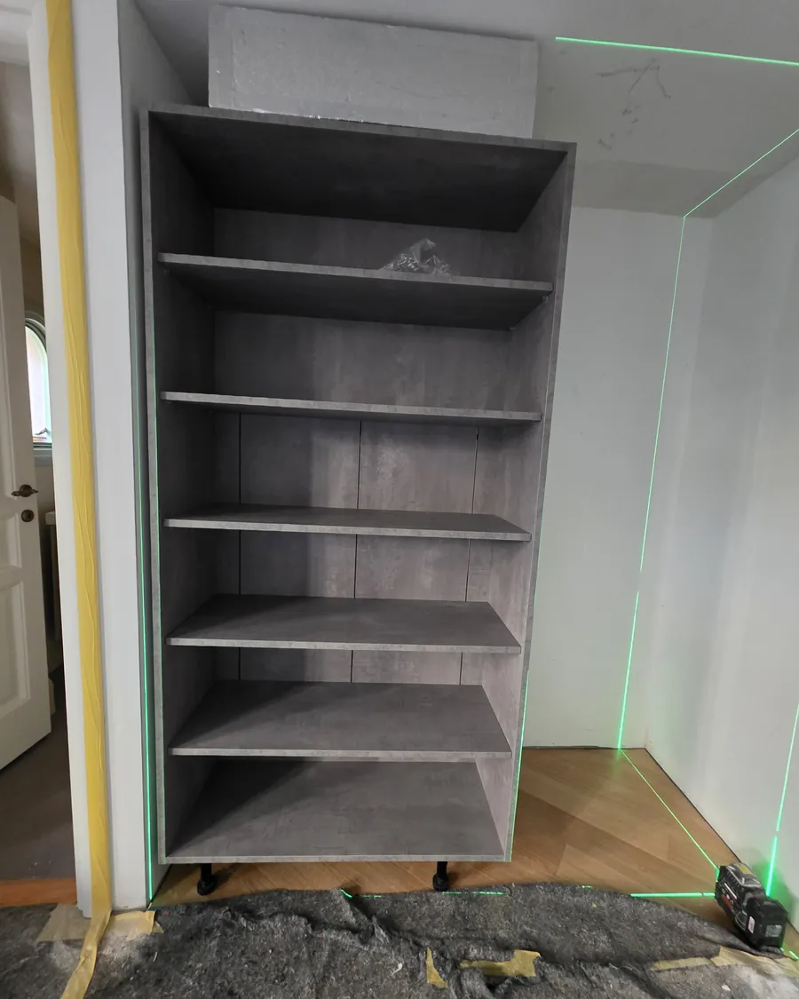 Wardrobe carcass being installed, aligned with a laser level